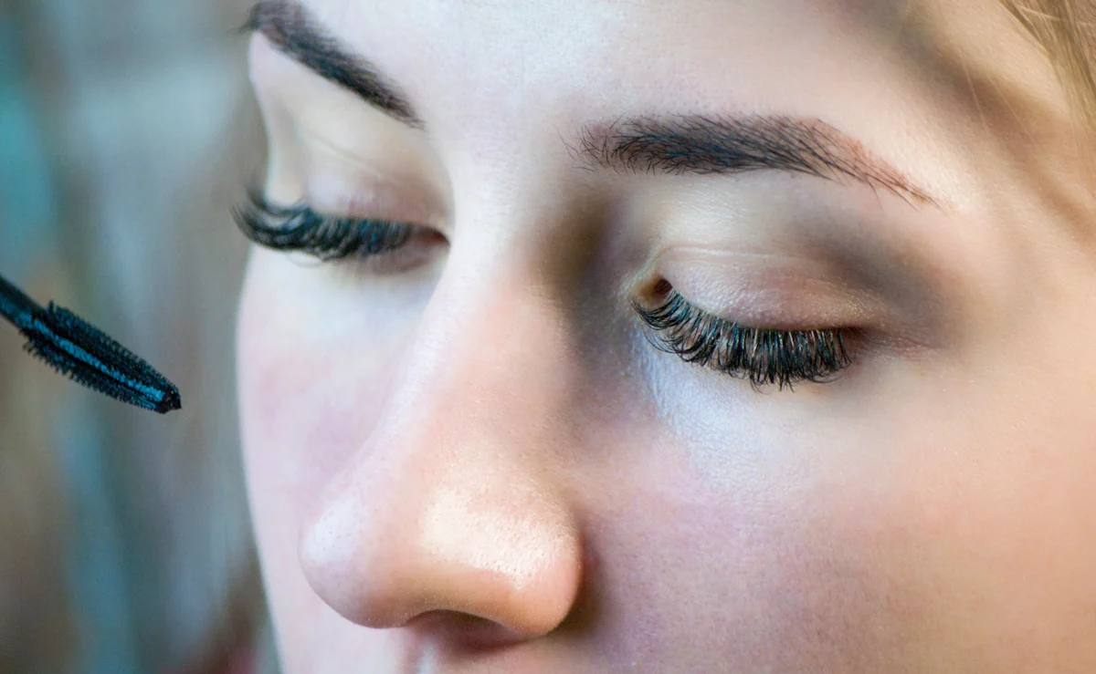 Une femme qui applique du mascaras waterproof