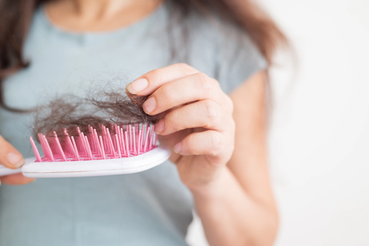Une femme qui prend des cheveux sur une brosse