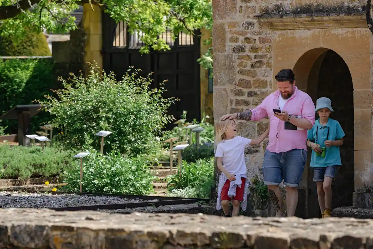 Un homme avec deux petites filles qui visite le Jardin du Luxembourg