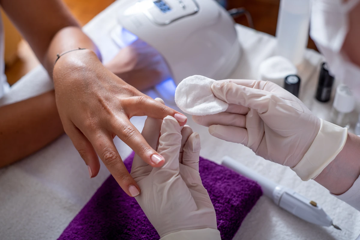Une personne qui fait un soin d'ongle cassé en institut