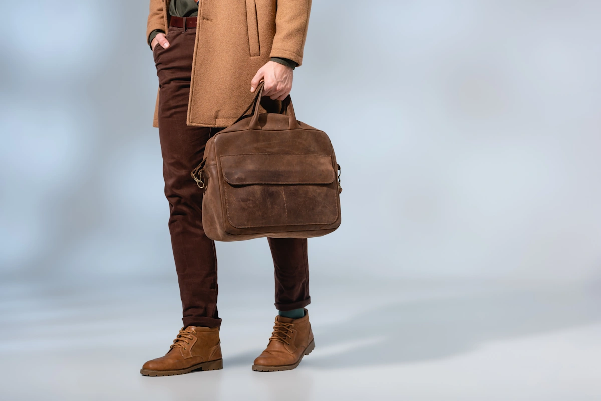 Un homme qui porte des chaussures cognac et un sac marron
