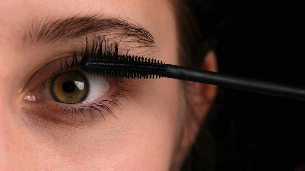 Une femme qui applique du mascara qui ne fait pas de paquets waterproof