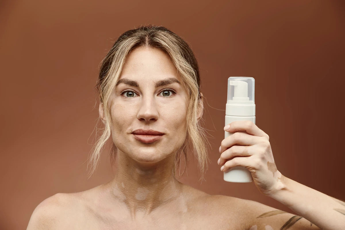 Une femme qui tient une bouteille de mousse autobronzante